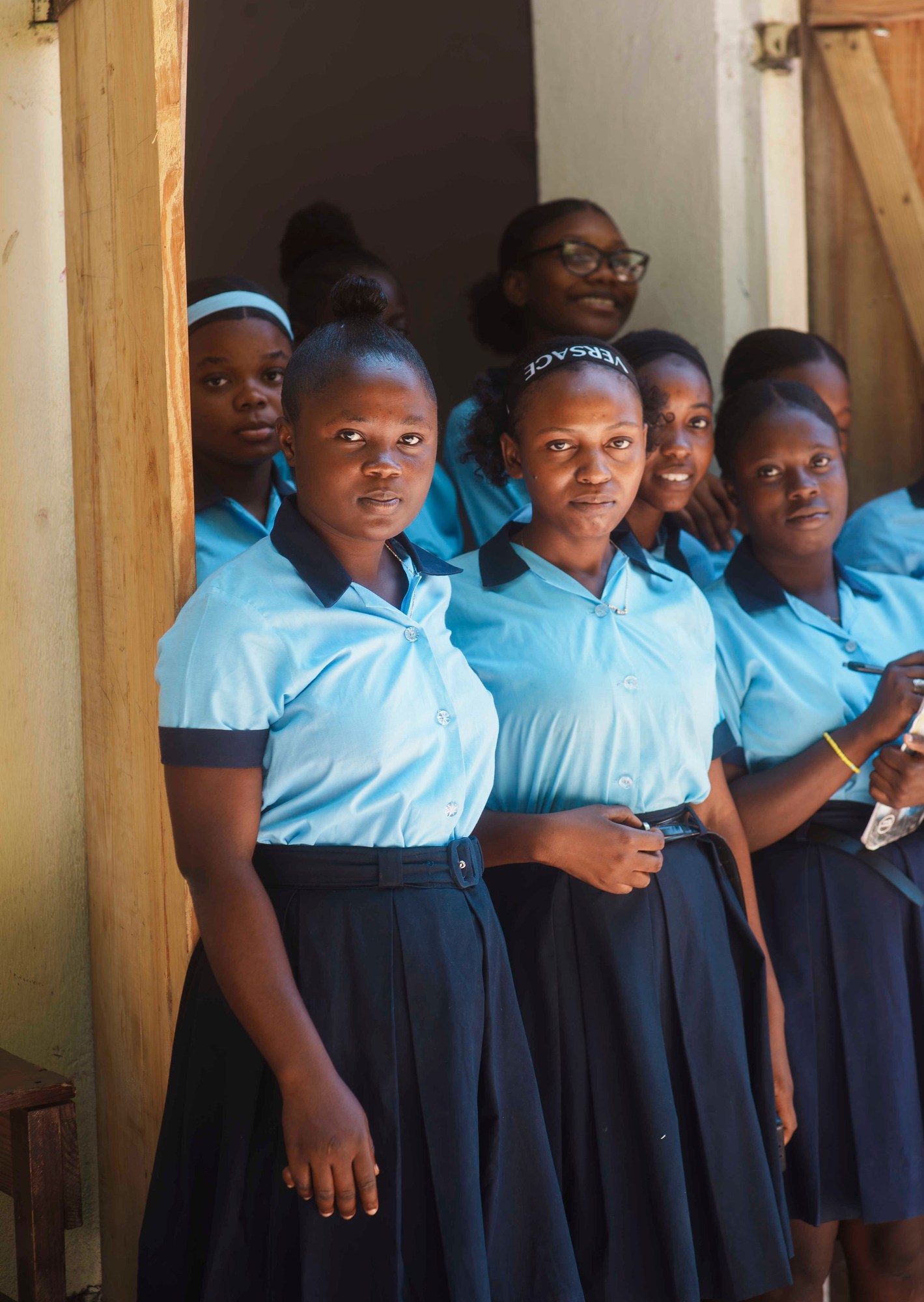 Students in blue uniforms gathered in a school doorway